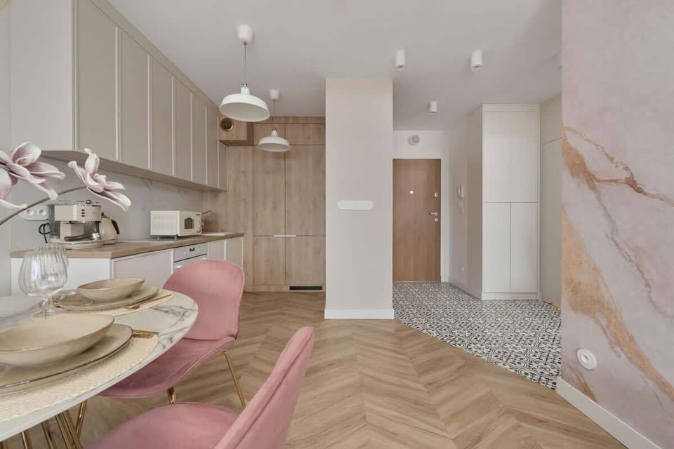 A beautifully decorated living area with a mix of modern and pastel-colored furniture.