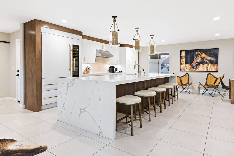 Spacious kitchen with waterfall island and open layout for hosting.