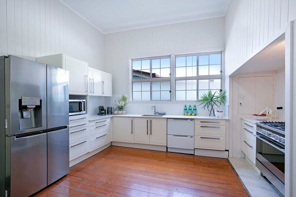 Kitchen with fridge, oven, stovetop, microwave, Nespresso and rice cooker.