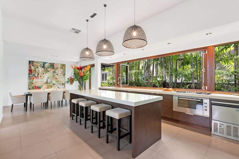 The open-plan kitchen and dining area seamlessly blend functionality with style, creating the perfect setting for lively gatherings or intimate family feasts.