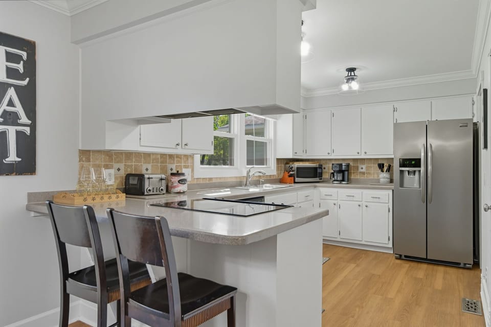 Two barstools off kitchen counter provide extra seating adjacent to Dining Room.
