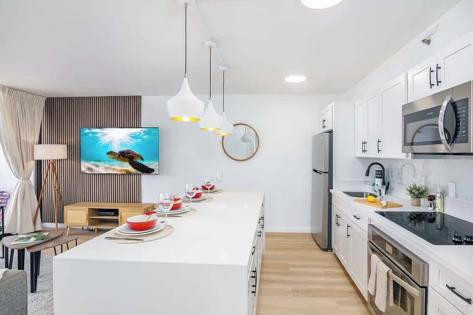 Step into a sleek, modern kitchen and living area, perfect for entertaining with a large island and all-new stainless steel appliances.