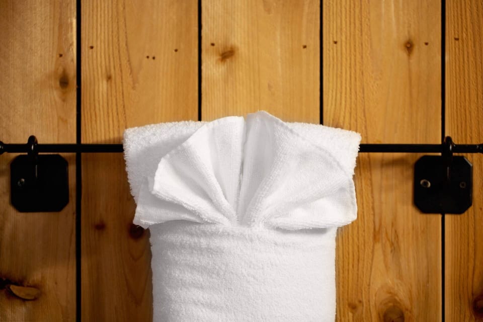 Indulge in comfort with the plush touch of fluffy white bath towels, provided in each rental.