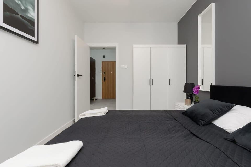 A stylish bedroom with a black-and-white theme, a large bed, and minimalist decorations.