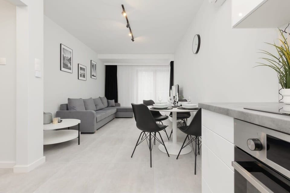A modern open-concept kitchen with a black dining table and chairs.