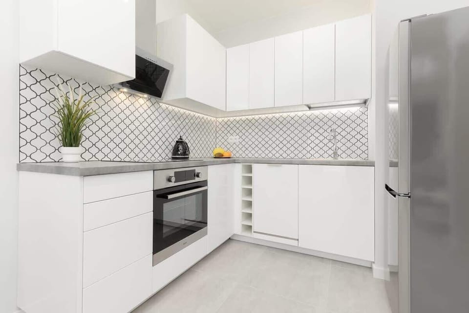 A modern open-concept kitchen with a black dining table and chairs.