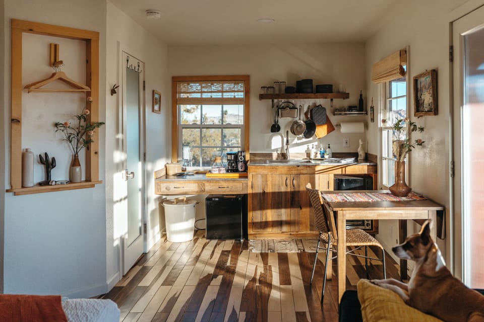 Sunlit rustic kitchenette with wood accents and a cozy dining nook