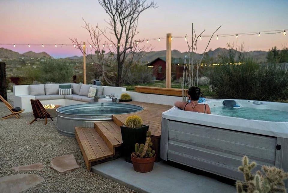 Desert oasis with hot tub, fire pit lounge, and sunset mountain views