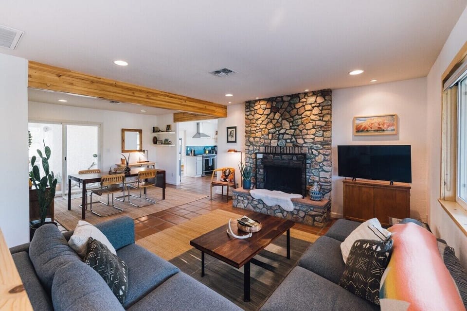 Open living room/dining room with beautiful local stone fireplace.