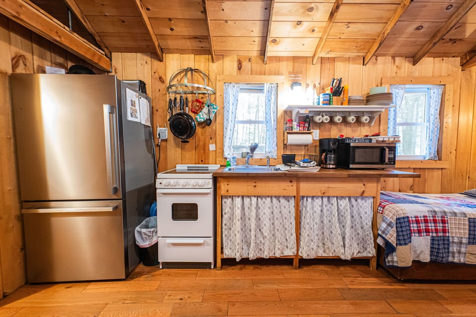 The kitchen has a refrigerator, stove, oven, microwave, coffee maker, & toaster