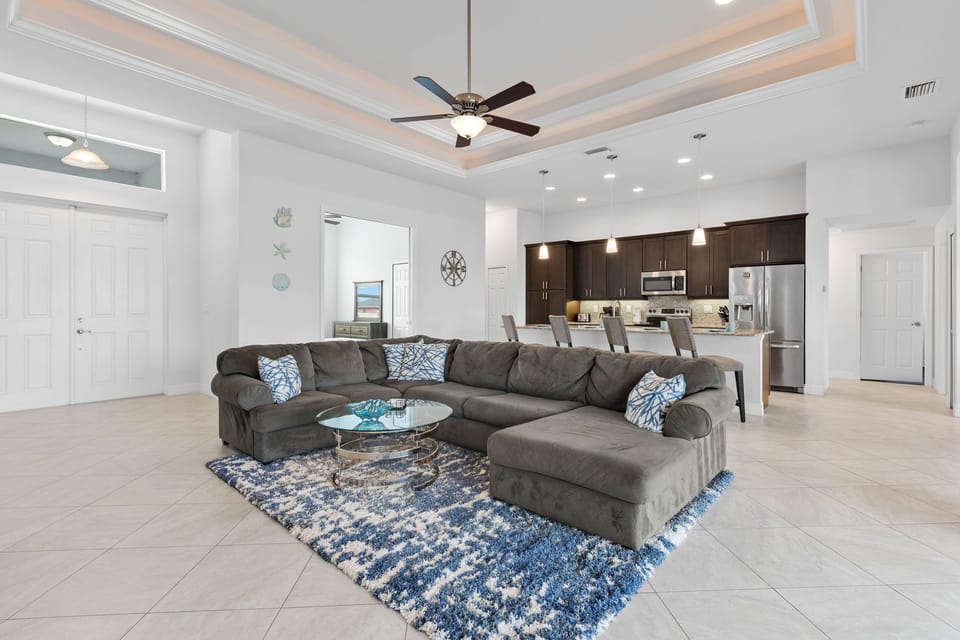 Open Elegance - - Gather in this stylish living area with a plush sectional and tasteful decor
- Seamlessly connected to the kitchen, it’s perfect for entertaining and family time
- High ceilings and modern lighting add a bright and airy ambiance to the space