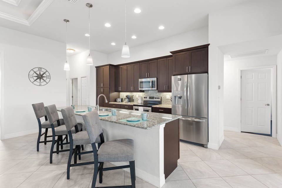 Modern Kitchen - - Cook in this sleek kitchen with stainless steel appliances and granite countertops
- Spacious island with seating makes it perfect for casual meals or entertaining
- Bright lighting and clean design create an inviting space to gather and enjoy