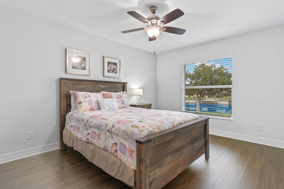Peaceful Bedroom - - Peaceful bedroom with a wooden bed frame adorned with soft, patterned bedding for ultimate comfort
- Large window offers serene views and fills the room with natural light
- Tasteful decor, and clean lines create a restful and inviting retreat