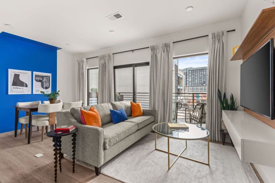 Living room with large windows and smart TV with dining area