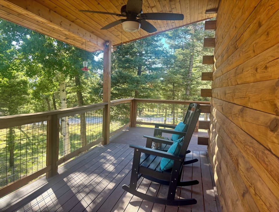 Covered deck with rocking chairs and peaceful forest views