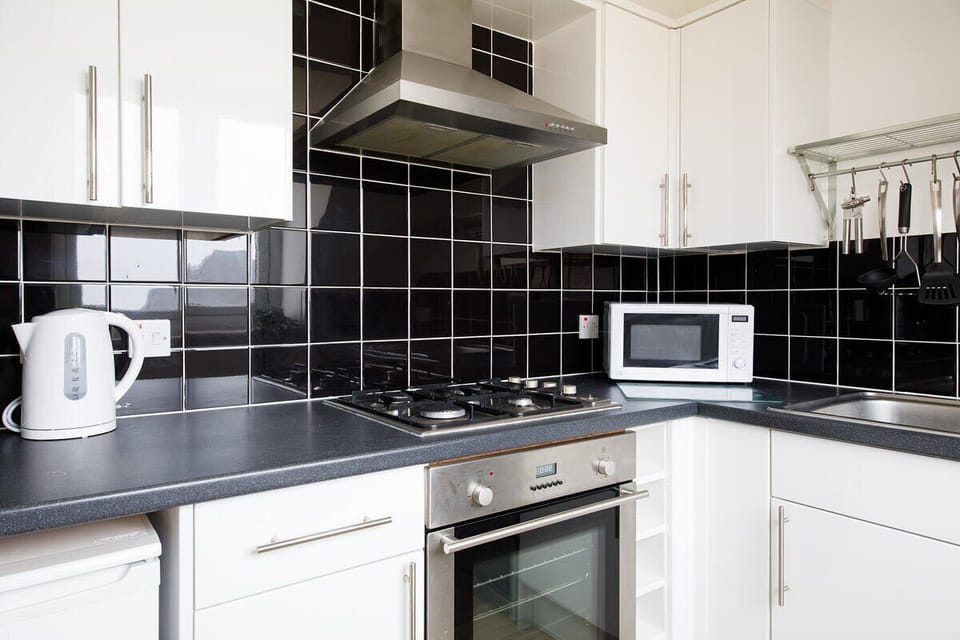 Fully-equipped kitchen with microwave, oven, gas hob, toaster, kettle and dishwasher.