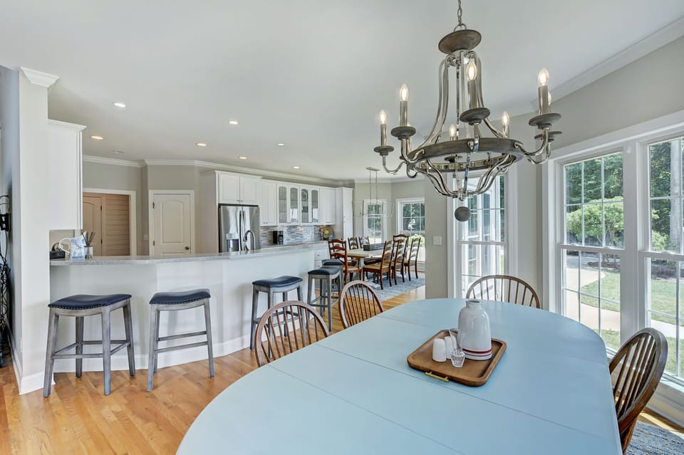 Inviting kitchen where natural light floods through two-story floor-to-ceiling windows.