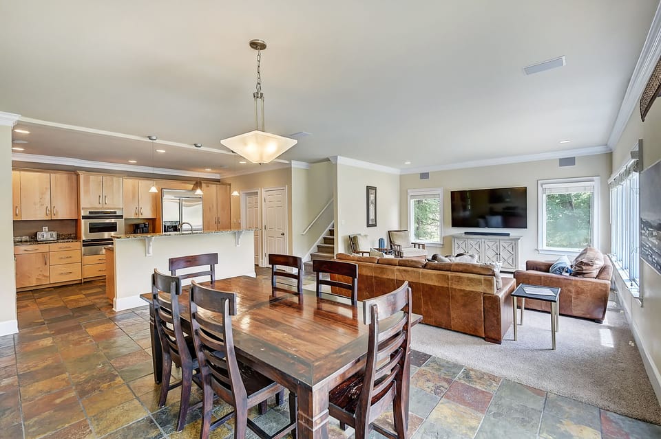 Open area with kitchen, living and dining area with sliders to the deck and large windows with lake views. 