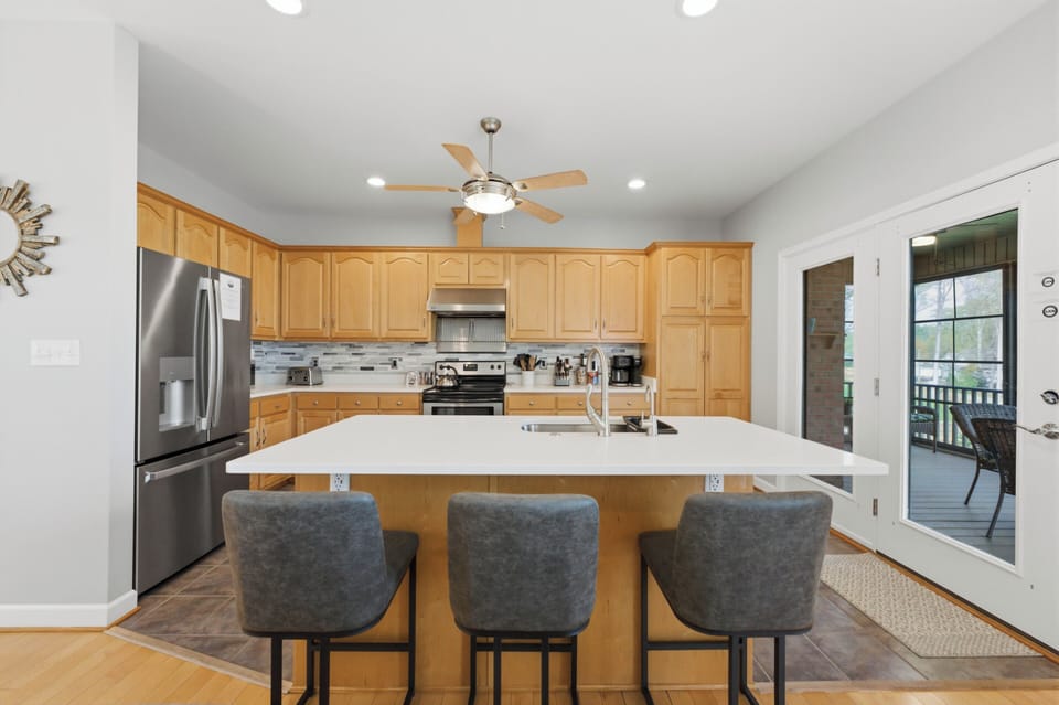 Updated kitchen with island featuring new countertops and backsplash. 