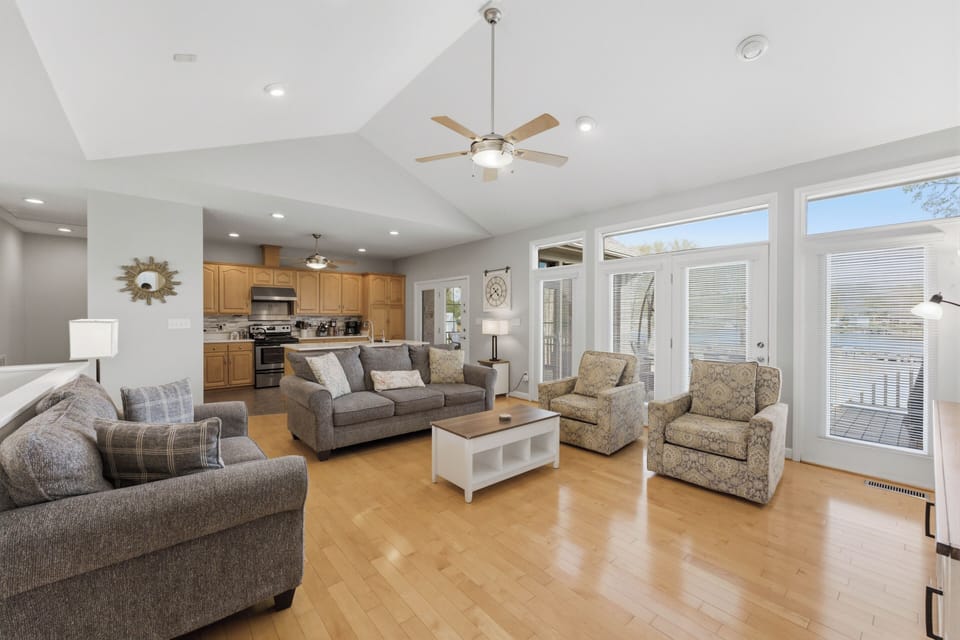 Living area with large TV and comfy couches and chairs. 