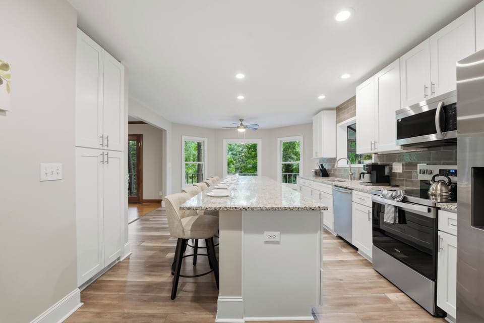 Spacious chef’s kitchen with oversized island seating and a bright, open layout made for gathering.