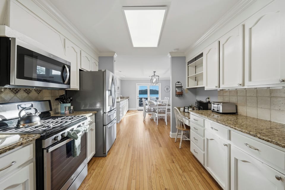A fully equipped kitchen offers generous counter space, stainless steel appliances, and abundant cabinetry for easy meal prep.