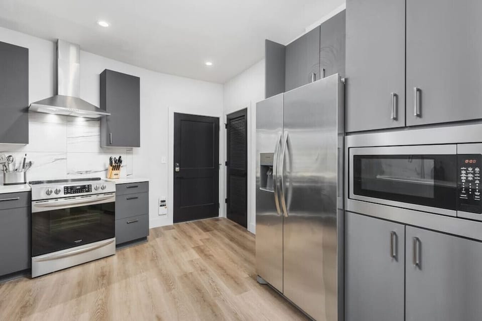 Fully-equipped kitchen with stainless steel appliances and every dish / utensil / tool you might need to enjoy a meal at home.