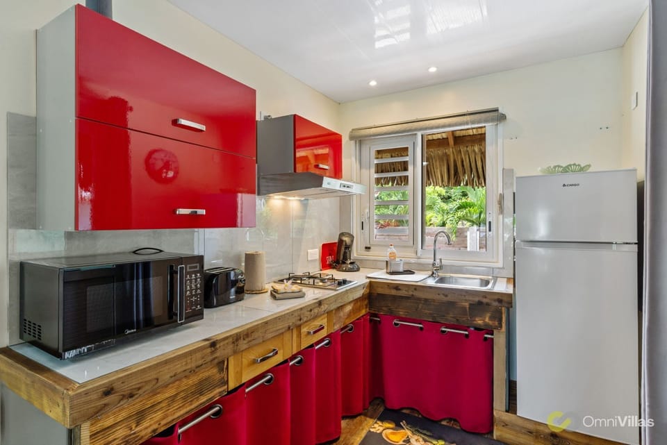 Bright kitchen with cabinets, fully equipped and sunlit.