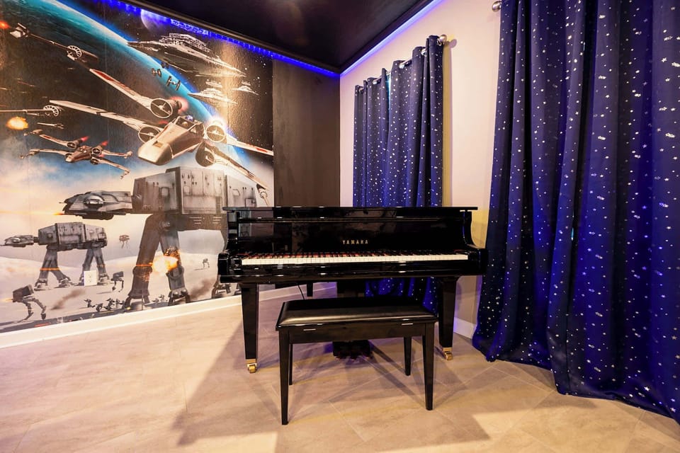 Immerse yourself in a galactic adventure with a stunning space-themed room featuring a Yamaha piano for your musical enjoyment.