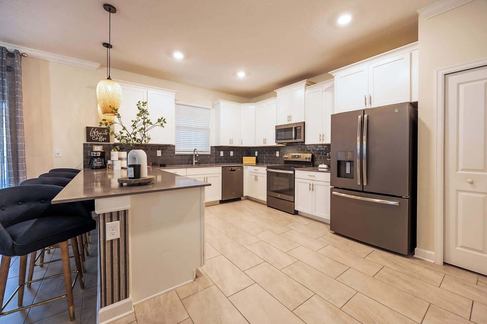Spacious modern kitchen with sleek appliances and a cozy breakfast bar, perfect for family gatherings.
