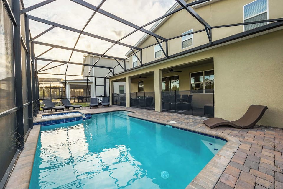 Relax by your private pool with a hot tub, perfect for unwinding under the screened enclosure. Enjoy the serene outdoor space in this spacious villa.