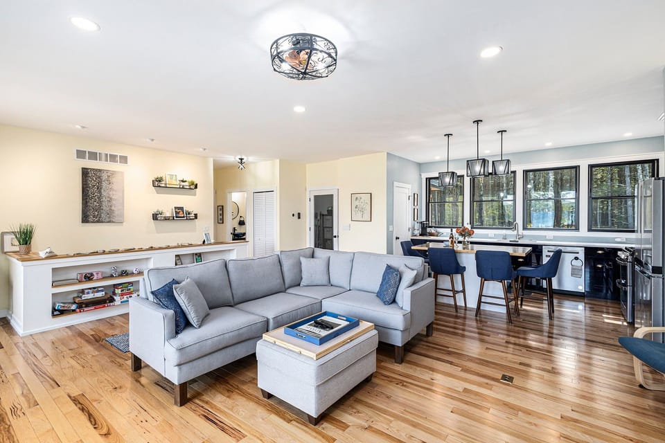 Open plan living room off of kitchen, opening to deck with a view of Torch Lake