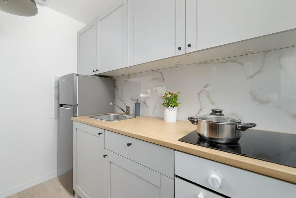 Another angle of the kitchen – white cabinets, a black countertop, and modern appliances.