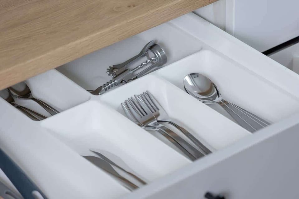 A close-up of a kitchen drawer with neatly arranged cutlery.