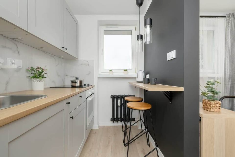 Another angle of the kitchen – white cabinets, a black countertop, and modern appliances.