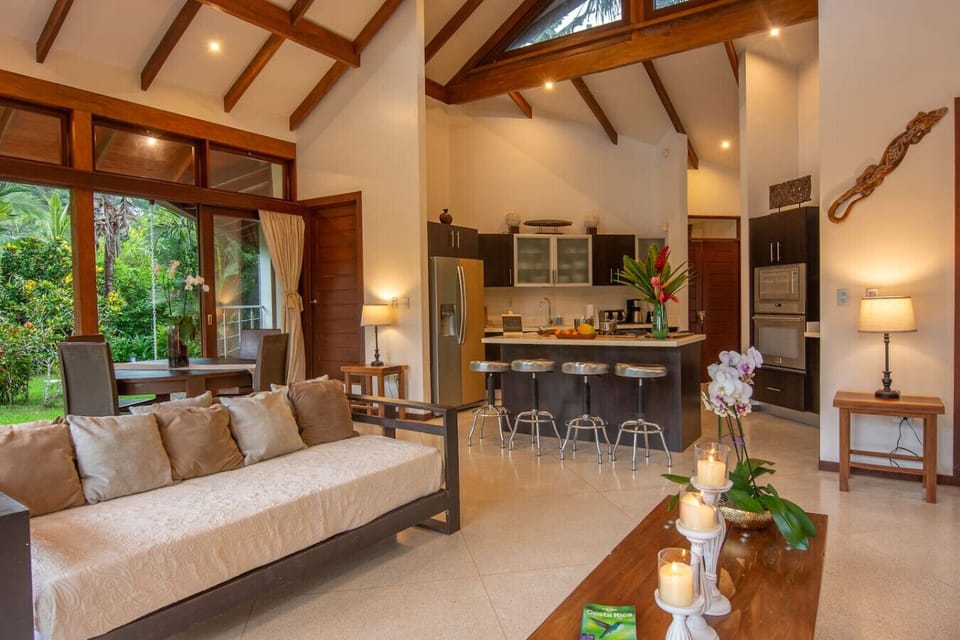 Open living area with kitchen, high ceilings, and a comfortable seating space at Three Monkeys, Cahuita, Costa Rica.