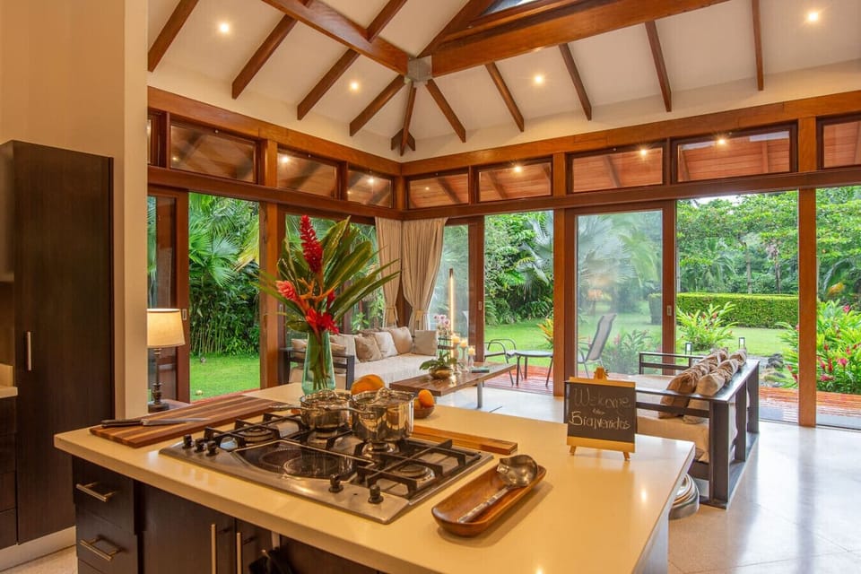 Open kitchen with central cooking area, modern appliances, and seamless connection to the living area at Three Monkeys, Cahuita, Costa Rica.