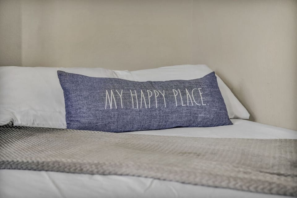 Bedroom 3 This cozy queen bed, adorned with the `My Happy Place` pillow, invites restful sleep and relaxation. It`s the perfect spot to recharge and make your vacation truly enjoyable.