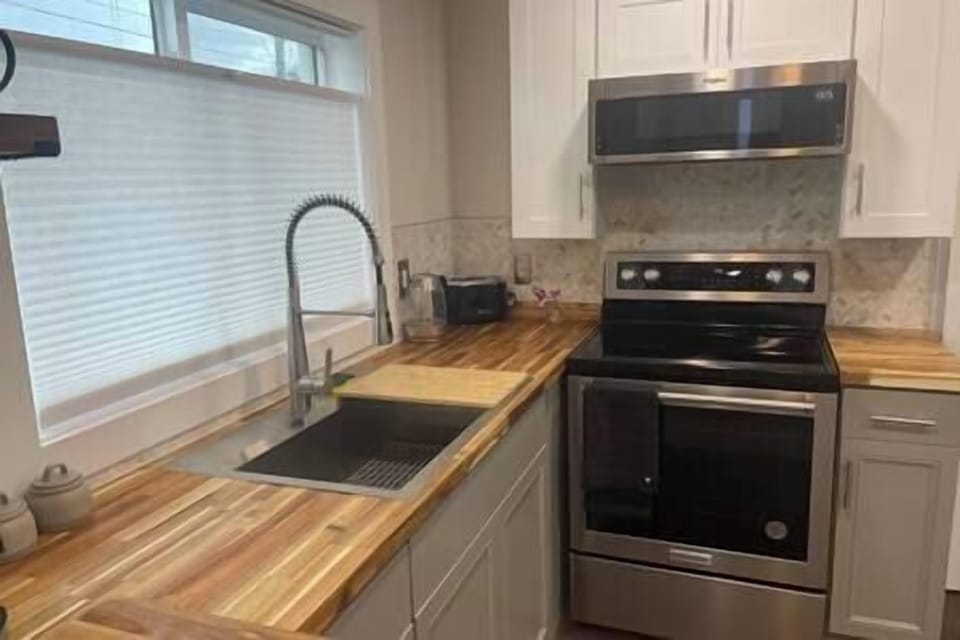 Kitchen featuring a brand-new cooking station and stainless-steel appliances