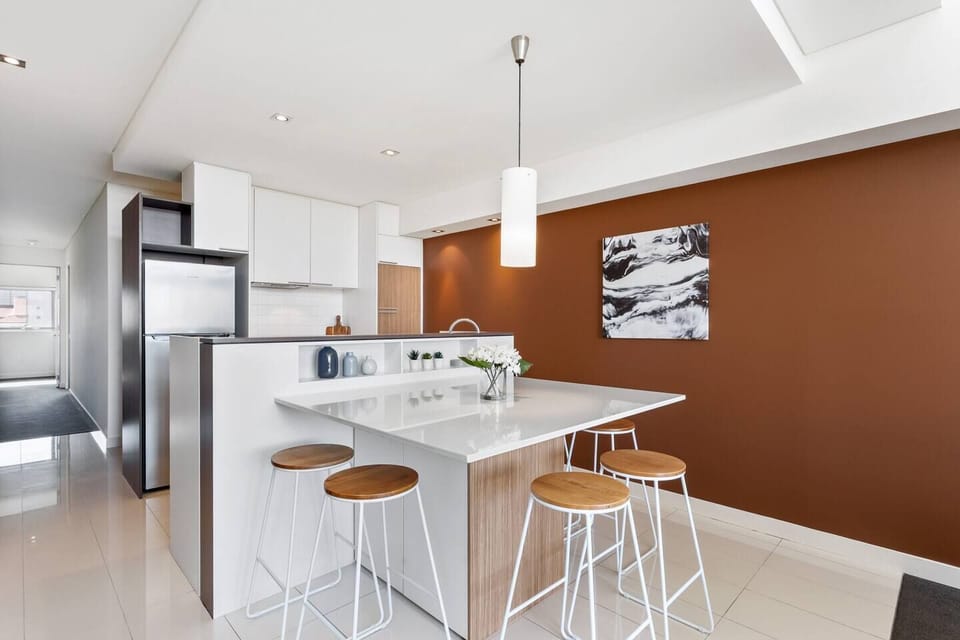 A modern and practical dining area, complete with stylish lighting and a breakfast bar for casual meals or morning coffee.