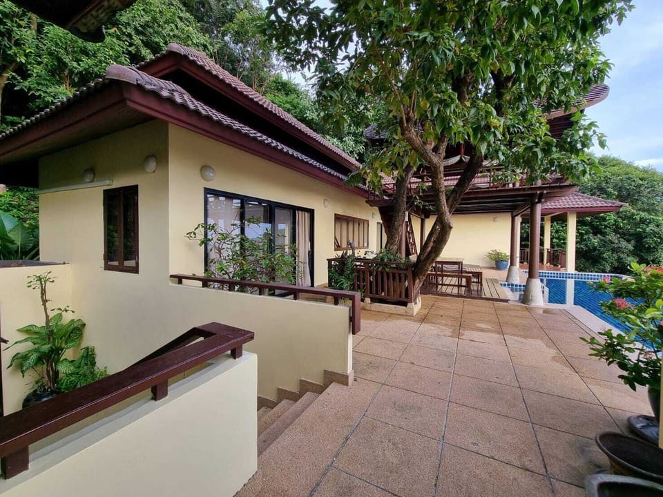 Villa exterior with infinity pool and tropical garden
