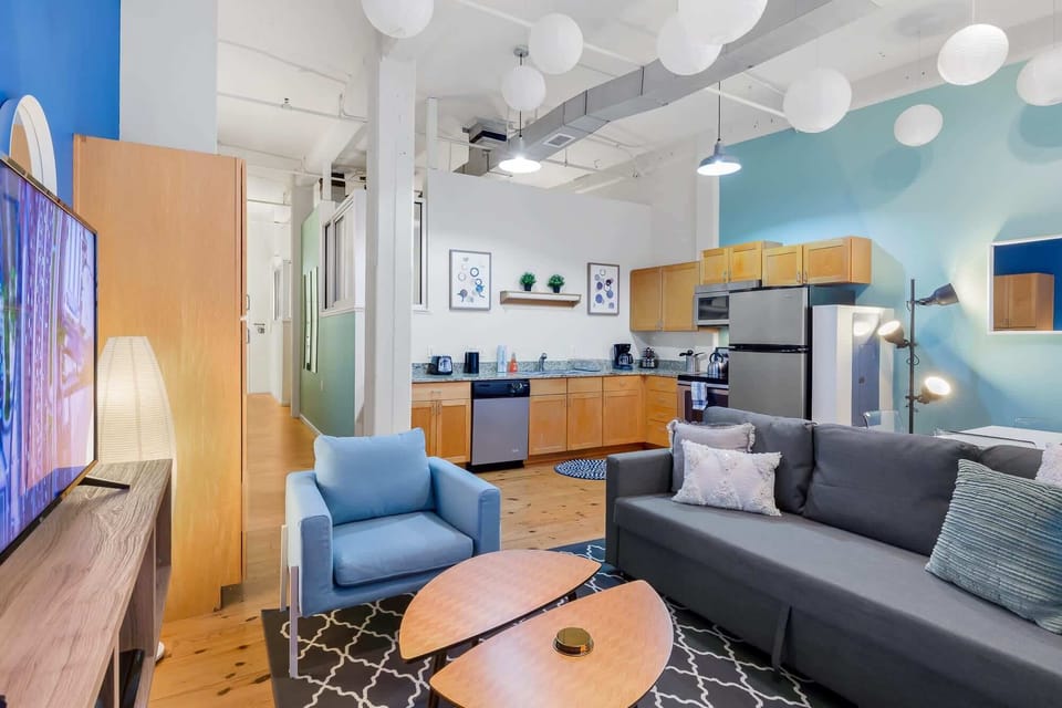 Living Room with 14 foot ceiling with authentic exposed brick & pipes.