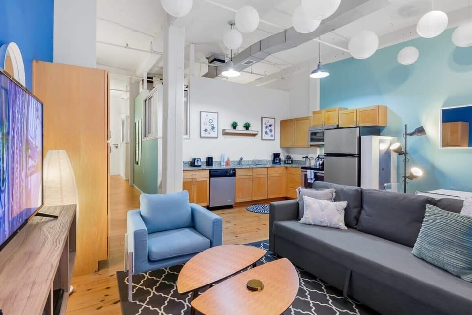 Living Room with 14 foot ceiling with authentic exposed brick & pipes.