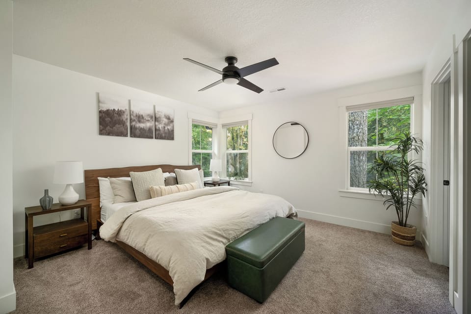 A serene primary king bed retreat with treetop views on two sides.