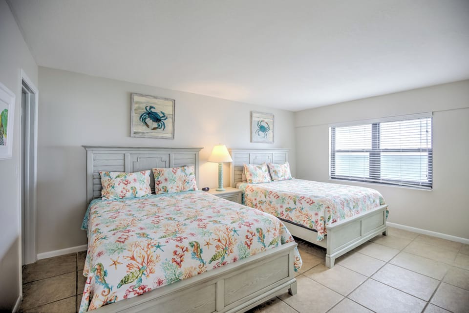 Guest suite with 2 queen beds and coastal decor