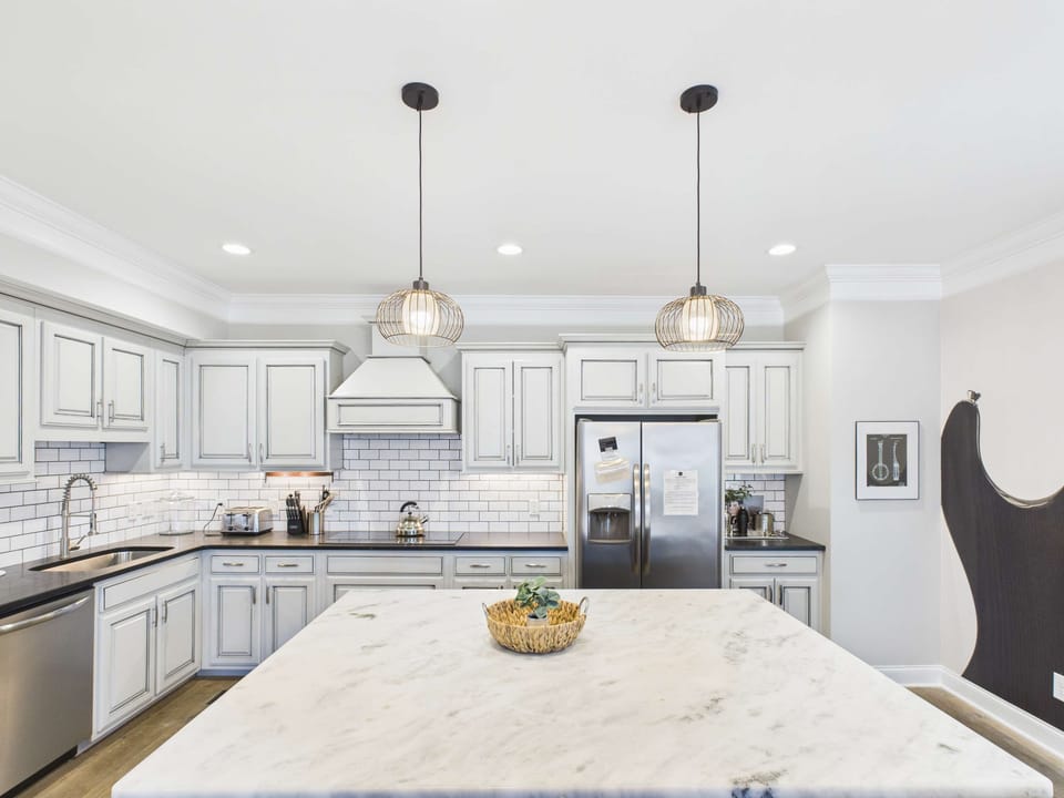 2nd Floor: Fully-equipped kitchen with stainless steel appliances, basic cooking essentials, a large island with bar seating, and wet bar.