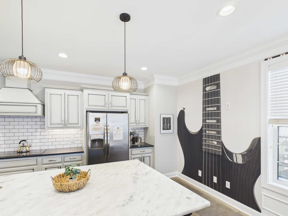 2nd Floor: Fully-equipped kitchen with stainless steel appliances, basic cooking essentials, a large island with bar seating, and wet bar.