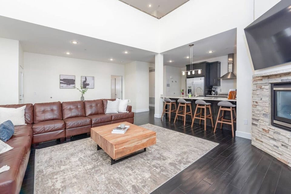 A cozy living room featuring a large sectional couch, gas fireplace, and smart TV for ultimate comfort and relaxation.