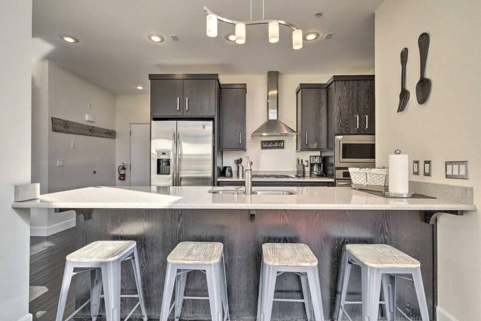 The breakfast bar features extra stools, providing plenty of seating for casual dining, morning coffee, or chatting while meals are prepared.