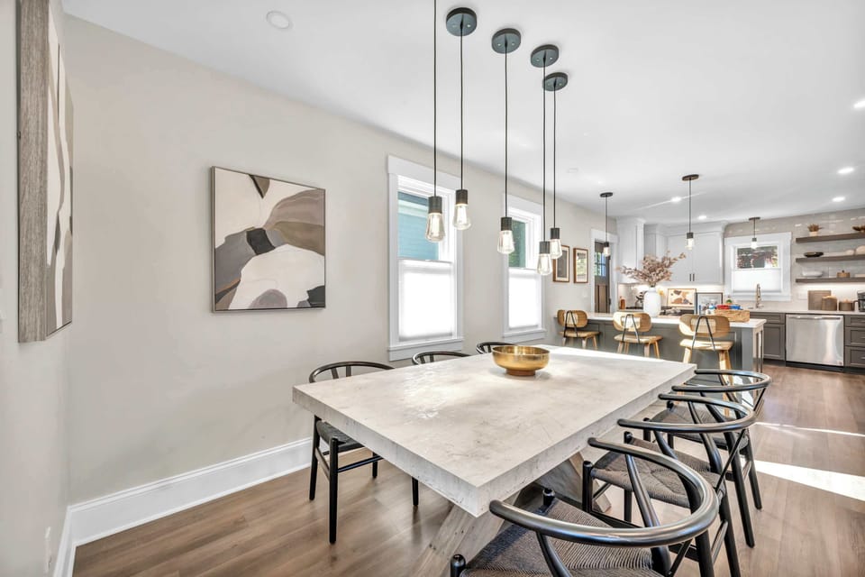 This sleek dining area features a modern table and artistic touches, offering a cozy space to share stories and savor delicious meals.
